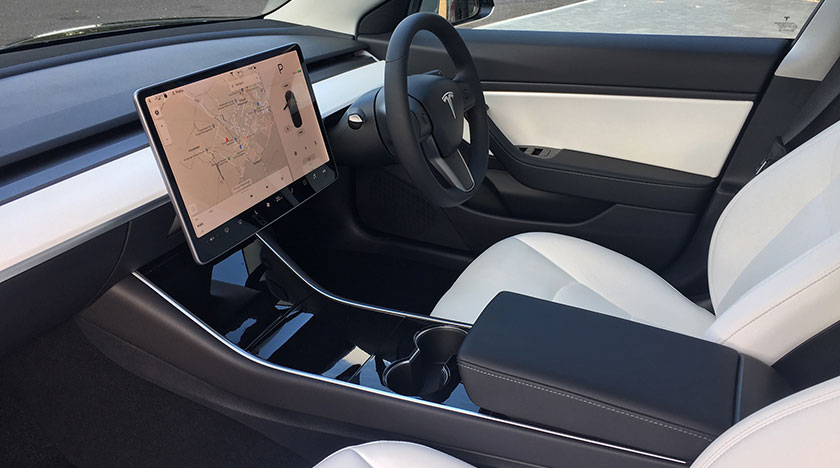 Car interior, showing the driver's seat and steering wheel with display